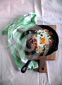 Shakshouka dish in tomato sauce with poached egg and spices