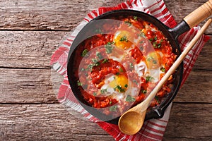 Shakshuka breakfast of fried eggs and tomatoes in a pan. horizon