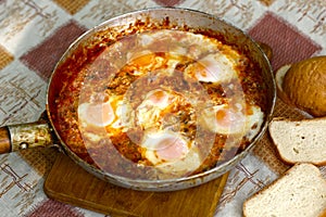 Shakshuka - jewish national dish with fried eggs species, tomato, pepper garlic
