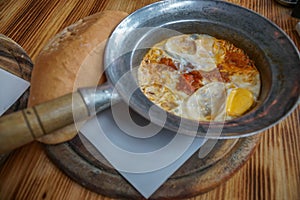 Shakshuka Poached Eggs with Tomato and Bread Served in a Frying Pan. Israeli Arab Middle Eastern Cuisine. Top View photo