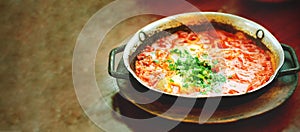 Shakshuka. Traditional jewish food and middle eastern cuisine recipe. Fried eggs, tomatoes, bell pepper and parsley in a