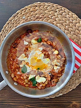 shakshuka, white beans in tomatoes, fried eggs with beans and tomatoes