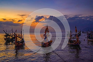 Moored boats during sunrise in Satelit Beach Banyuwangi photo