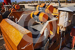 Shale shaker on an offshore oil rig. Shale shaker screen close up view with drill cutting flow out from oil base mud. Separators