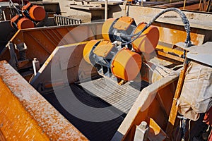 Shale shaker on an offshore oil rig. Shale shaker screen close up view with drill cutting flow out from oil base mud. Separators