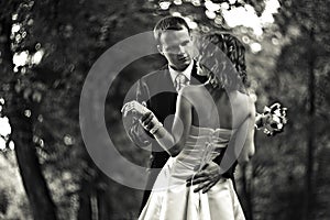 Shall we dance? - Groom leads a bride to dance in a park photo