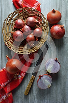 Shallots onions, a knife and a red kitchen towel