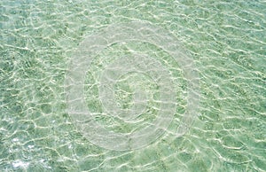 Shallow crystal clear water in the tropical sea, ripples and reflections. texture as background
