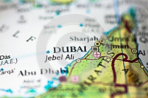 Shallow depth of field focus on geographical map location of Dubai city in United Arab Emirates Asia continent on atlas