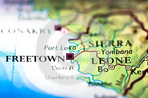 Shallow depth of field focus on geographical map location of Freetown city in Sierra Leone Africa continent on atlas