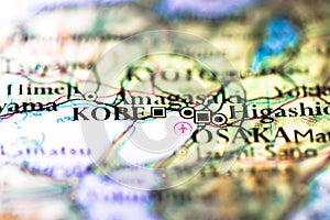 Shallow depth of field focus on geographical map location of Kobe city in Honshu Island Japan Asia continent on atlas