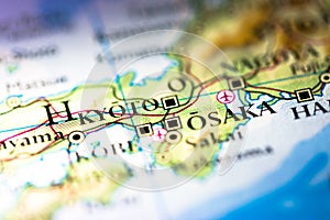 Shallow depth of field focus on geographical map location of Kyoto Osaka twin city in Honshu Island Japan Asia continent on atlas