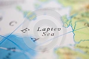 Shallow depth of field focus on geographical map location of Laptev Sea off coast of Russia on atlas photo