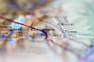 Shallow depth of field focus on geographical map location of Mount Kilimanjaro in Tanzania Africa continent on atlas