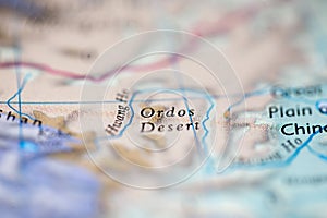 Shallow depth of field focus on geographical map location of Ordos Desert China Asia continent on atlas