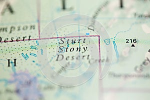 Shallow depth of field focus on geographical map location of Sturt Stony Desert Australia Oceania continent on atlas