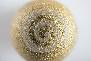 Shallow depth of field of gold glitter colored Christmas bauble.