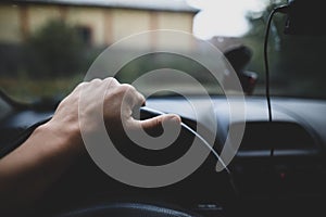 Shallow depth of field image with the hand of a driver on the steering wheel