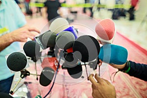 Shallow depth of field image with microphones installed by journalists at a press conference - politician point of view