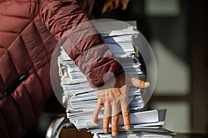 Shallow depth of field selective focus image with the hands of a man picking up a pile of files