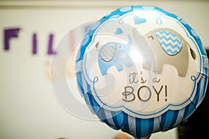 Shallow depth of field selective focus image with a Itâ€™s a boy message on a balloon during a baby shower