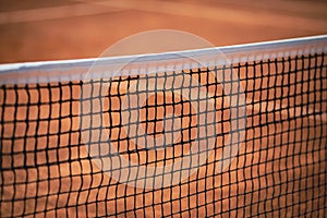 Shallow depth of field selective focus image with the net of a clay tennis court