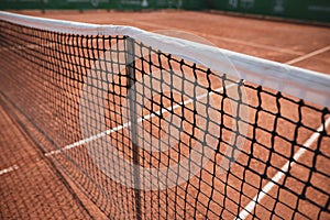 Shallow depth of field selective focus image with the net of a clay tennis court