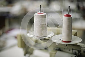 Shallow depth of field selective focus image with thread spools in a textile factory