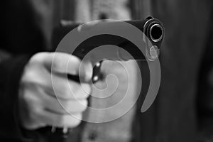 Shallow DOF image of a criminal brandishing a gun.