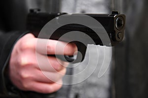 Shallow DOF image of a criminal brandishing a gun.