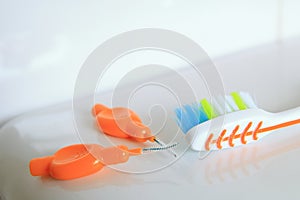 Shallow DOF shot of a toothbrush and interdental brushes on a shiny surface