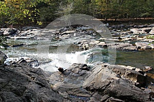 The shallow Eno River flowing over rocks and boulders in Umstead State Park, Durham, North Carolina