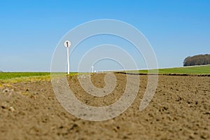 Shallow focus of a 1 furlong sign seen next to a race horse training track seen from ground level.