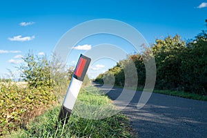 Shallow focus of a bent over, plastic traffic bollard.