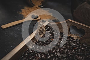Shallow focus closeup shot of coffee beans and grounds with a wooden spoon