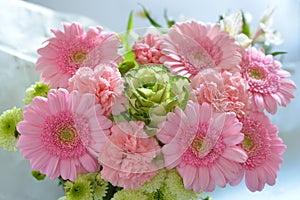 Shallow focus closeup shot of a pink bouquet of Transvaal Daisy, Lily, Rose, Peony flowers