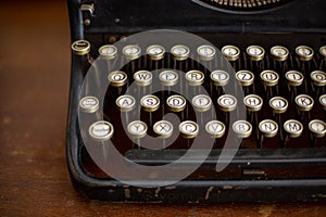 Shallow focus closeup shot of a vintage manual typewriter on a wooden table