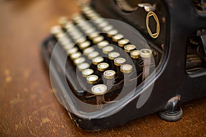 Shallow focus closeup shot of a vintage manual typewriter on a wooden table