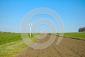 Shallow focus of a 1 furlong sign seen next to a race horse training track