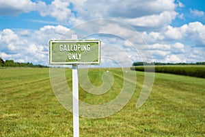 Shallow focus of a Galloping Only sign at an outdoor horse acing venue.