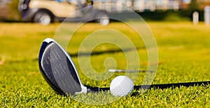 Shallow focus of a golf club and a ball on a lawn