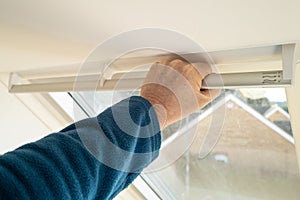 Shallow focus of a homeowner seen gripping the bar on a newly installed Skylight window. photo