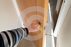 Shallow focus of a homeowner seen opening the door.