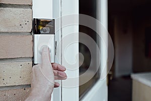 Shallow focus of a homeowner seen testing a newly installed WiFi smart doorbell. photo