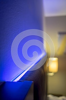 Shallow focus of modern LED ambient mood lighting seen in a modern apartment bedroom.