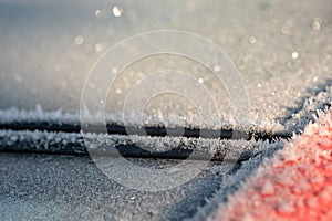 Shallow focus of part of a heavily frosted windshield and glass panoramic roof of a car during mid winter.