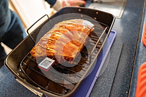 Shallow focus on the point where a thermometer enters a pork loin join so the temperature of the cooked meat can be measured