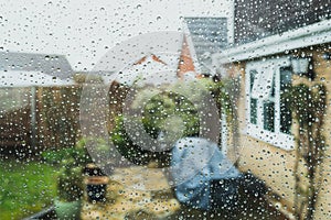 Shallow focus of raindrops seen on a conservatory window.