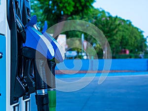 Shallow focus shot of blue gasoline pumps in gas station with blur trees in the background