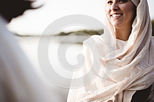 Shallow focus shot of a female wearing a biblical robe while talking to Jesus Christ